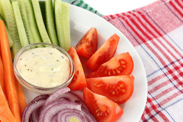 Assorted raw vegetables sticks in plate on napkin close up