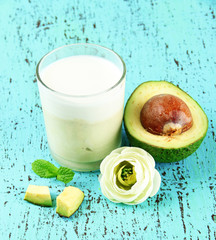 Fresh avocado smoothie on wooden background