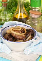 Fried chicken livers in pan on wooden table close-up
