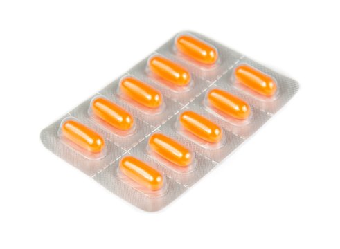 orange pills packed in blister isolated