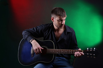 Fototapeta na wymiar Young musician playing acoustic guitar and singing,