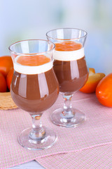 Dessert of chocolate and persimmon on table on light background