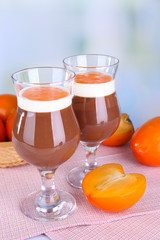 Dessert of chocolate and persimmon on table on light background