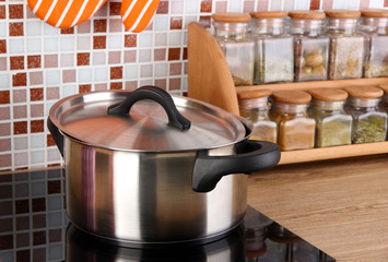 Pot on stove in kitchen on table on mosaic tiles background