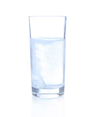 Glass with efervescent tablet in water with bubbles isolated