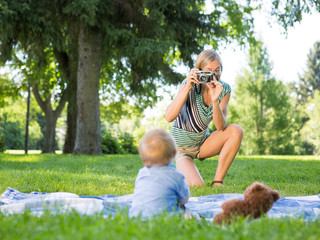 Mother Photographing Baby Boy At Park