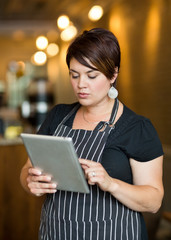 Owner Using Digital Tablet In Cafe