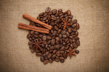 Coffee beans heap with spices on sack cloth background