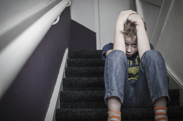 scared boy on stairs, child abuse