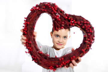 Kaukaska dziewczynka patrzy przez  czerwone walentynkowa serce