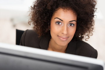 schöne frau schaut über computer-bildschirm