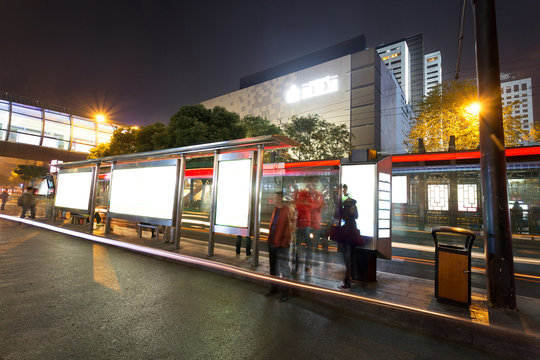 Blank billboard on bus stop at night