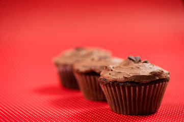 Close-up of colorful red muffins with dark chocolate topping