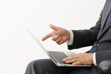 ノートパソコンを指差すビジネスマン