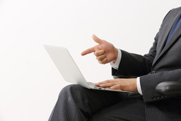 ノートパソコンを指差すビジネスマン