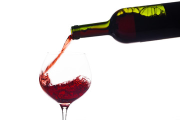 Rotwein wird in ein Weinglas eingegossen