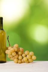 bottle of white wine with bunch of white grapes