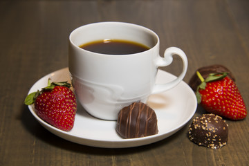 Cup of coffee with chocolate and strawberries