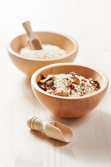 Rice in wooden bowl with ingredients for risotto