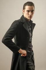 Beautiful man wearing a black shirt, pants and a long coat