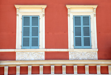 Fototapeta na wymiar old french blue shutter windows in red house, Nice, France.