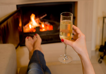 woman drinking Champange in front of a fire