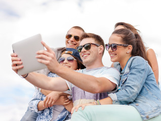 Fototapeta premium group of smiling teenagers looking at tablet pc