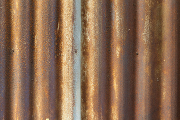 Rusty old corrugated iron fence close up