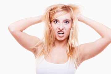 Fototapeta premium Stress. Young woman frustrated pulling her hair on white