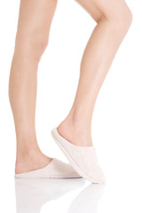 Female's feet with white slippers.