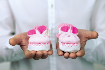 young man holding baby booties