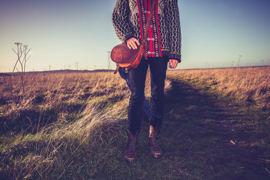 Young woman with handbag standing on nature trail