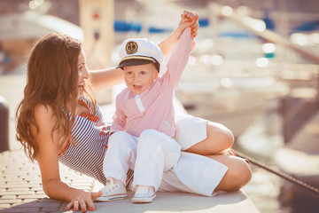 portrait of mother and son playing on the jetty by the sea