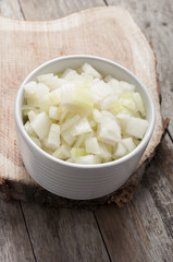 cut onion on white bowl in wooden background