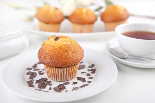 Vier Muffins mit einer Tasse Tee