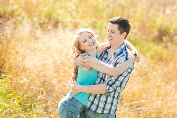 Happy young adult couple in love on the field. Two,  man and wom