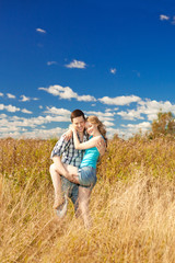 Happy young adult couple in love on the field. Two,  man and wom