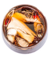 Cola drink with ice cubes in a short glass over white background