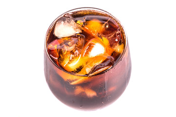 Cola drink with ice cubes in a short glass over white background