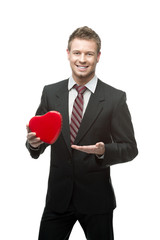 young cheerful businessman holding red heart