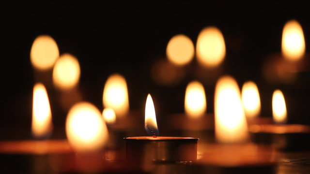 Candles light, black background.