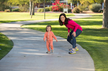 Beautiful mother and daughter running in the neighborhood