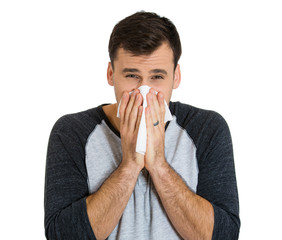 Closeup portrait of sick young man blowing his nose 