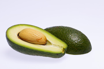 half avocado with stone isolated on white background