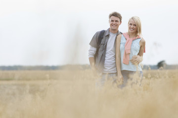Happy young couple standing at field