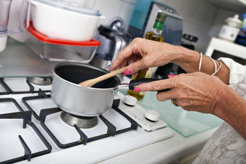 Cropped image of senior woman cooking at kitchen counter