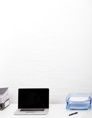 Laptop and paper tray on office desk