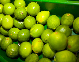 Close-up of green lemons on display in grocery store