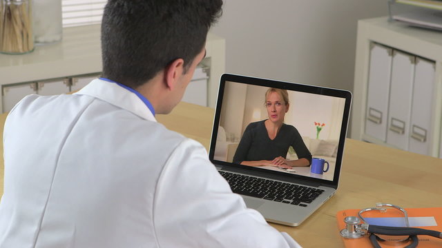 Hispanic Doctor talking to patient through video chat