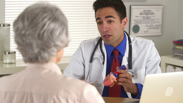 Mexican doctor talking to elderly patient about heart